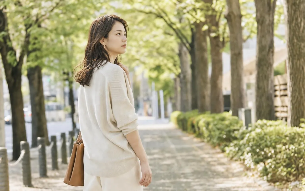 並木道で、静かに前を見ている女性